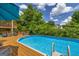 Inviting in-ground pool surrounded by a wood deck and lush landscaping, perfect for relaxing and entertaining at 684 Doe Lane Ln, Loganville, GA 30052