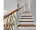 Bright staircase featuring wood trim and white risers and walls, leading to the upper level at 684 Doe Lane Ln, Loganville, GA 30052