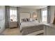 A stylish bedroom showcases a cozy bed, matching nightstands, and elegant curtains at 11899 Aukerman Way, Hampton, GA 30228
