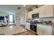 Well-lit kitchen boasts granite countertops, stainless steel appliances, and ample cabinet space at 11899 Aukerman Way, Hampton, GA 30228