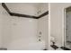 Full white bathtub with tiled walls and black accent border in a clean bathroom at 1102 Wynnes Ridge Cir, Marietta, GA 30067
