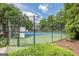 Community tennis court surrounded by lush greenery and a secure fence at 1102 Wynnes Ridge Cir, Marietta, GA 30067