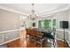 Dining room features a chandelier, hardwood floors, a wooden table with chairs, and natural light from the windows at 1285 Willow Park Way, Cumming, GA 30041