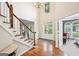 Elegant foyer with hardwood floors, a staircase with white railings, and a view of the double-door entryway at 1285 Willow Park Way, Cumming, GA 30041