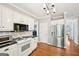 Well-lit kitchen with white cabinets, stainless steel appliances, black countertops, and hardwood floors at 1285 Willow Park Way, Cumming, GA 30041