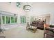 Open-concept living room boasts a chandelier, neutral carpet, brown leather sofas, and access to the kitchen and sunroom at 1285 Willow Park Way, Cumming, GA 30041