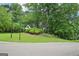 Home nestled amongst mature trees, viewed from the street at 1285 Willow Park Way, Cumming, GA 30041