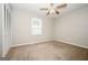This bedroom features neutral walls, carpet flooring, a window with blinds, and a ceiling fan at 6194 Golden Meadow Court Ct, Riverdale, GA 30296