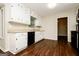 A well-lit kitchen features white cabinets, a black dishwasher, and wood-look flooring at 6194 Golden Meadow Court Ct, Riverdale, GA 30296
