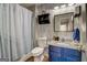 Well-lit bathroom showcasing a blue vanity, mirror, and shower with a neutral-patterned shower curtain at 1753 Liberty Pkwy, Atlanta, GA 30318