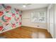 Cozy bedroom featuring a floral accent wall, hardwood floors, and lots of natural light at 2855 Briarlake Ne Rd, Atlanta, GA 30345