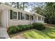 Attractive single-story home displaying a white brick exterior, dark shutters, and lush landscaping at 2855 Briarlake Ne Rd, Atlanta, GA 30345