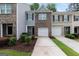 A brick townhouse with attached one car garage and lush landscaping at 3155 Tarian Way, Decatur, GA 30034
