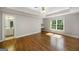 Spacious bedroom with hardwood floors, a ceiling fan, large window and a glimpse into the bathroom at 125 Franklin Pl, Atlanta, GA 30342