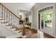 Elegant foyer with hardwood floors, staircase with iron spindles, and a glimpse into the bright living room at 125 Franklin Pl, Atlanta, GA 30342