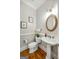 Charming powder room featuring a pedestal sink, hardwood floors, and classic decor at 125 Franklin Pl, Atlanta, GA 30342