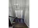 Elegant entryway with dark wood stairs, modern chandelier and bright view through the front door at 946 Creek Run Pl, Temple, GA 30179
