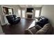 Spacious living room featuring a cozy fireplace, dark wood flooring, and comfortable seating at 946 Creek Run Pl, Temple, GA 30179