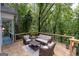 Relax on the wood deck with outdoor seating surrounded by a lush, wooded landscape at 145 Mount Shasta Ln, Johns Creek, GA 30022