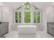 Bright bathroom with stand alone tub, large windows with wooded views, and modern fixtures at 145 Mount Shasta Ln, Johns Creek, GA 30022