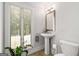 Cozy bathroom with a pedestal sink, a toilet, and natural light through the window at 145 Mount Shasta Ln, Johns Creek, GA 30022