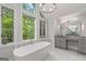 Bright bathroom with stand alone tub, large windows with wooded views, granite counters and modern fixtures at 145 Mount Shasta Ln, Johns Creek, GA 30022