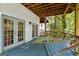 Covered deck with a hammock and tall trees beyond the railing at 145 Mount Shasta Ln, Johns Creek, GA 30022