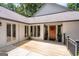 Charming front entrance with a wooden deck, decorative plants, and large windows at 145 Mount Shasta Ln, Johns Creek, GA 30022
