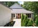 Inviting front entrance with wooden door, elegant landscaping, and stylish architectural details at 145 Mount Shasta Ln, Johns Creek, GA 30022