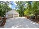 Detached two-car garage with a large driveway and mature trees providing ample shade at 145 Mount Shasta Ln, Johns Creek, GA 30022