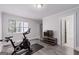Bright gym showcasing an exercise bike, TV, and a view of the bathroom at 145 Mount Shasta Ln, Johns Creek, GA 30022