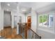 Landing with hardwood floors, a large window, and staircase leading to the lower level at 145 Mount Shasta Ln, Johns Creek, GA 30022