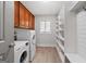 Bright laundry room with washer, dryer, shelving, and wooden accents at 145 Mount Shasta Ln, Johns Creek, GA 30022