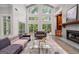 Elegant living room with a fireplace, built-in shelves, and large windows overlooking the yard at 145 Mount Shasta Ln, Johns Creek, GA 30022