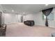 Bright living room featuring neutral walls, plush carpet, and a modern gray sofa at 145 Mount Shasta Ln, Johns Creek, GA 30022