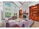 Cozy living room with built-in shelving, a fireplace, and sliding doors to the backyard patio at 145 Mount Shasta Ln, Johns Creek, GA 30022