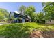 Expansive backyard with mature trees, a storage shed, and a charming blue house at 178 Castleair Ne Dr, Kennesaw, GA 30144