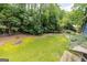 Expansive backyard with a fire pit and dense greenery, creating a private outdoor oasis at 178 Castleair Ne Dr, Kennesaw, GA 30144
