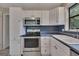 Bright kitchen featuring stainless steel appliances and ample white cabinet space at 178 Castleair Ne Dr, Kennesaw, GA 30144