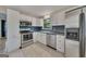 Modern kitchen featuring white cabinets, stainless steel appliances, and stylish tile flooring at 178 Castleair Ne Dr, Kennesaw, GA 30144