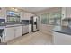Well-lit kitchen with white cabinets, stainless steel appliances, and neutral-toned tile floors at 178 Castleair Ne Dr, Kennesaw, GA 30144