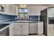 Well-lit kitchen with white cabinetry, blue countertops, and stainless steel appliances at 178 Castleair Ne Dr, Kennesaw, GA 30144