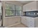 A well-lit kitchen with white cabinetry, dark countertops, and stainless steel refrigerator at 178 Castleair Ne Dr, Kennesaw, GA 30144
