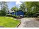 Property featuring green lawn, showcasing the rear of the home with a covered porch and ample parking space at 178 Castleair Ne Dr, Kennesaw, GA 30144