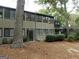 Exterior view of a two-story townhouse, showing the rear entry, mature trees and landscaping at 37 La Rue Nw Pl, Atlanta, GA 30327