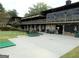 Exterior of golf clubhouse with an outdoor covered patio and golf putting green in the foreground at 37 La Rue Nw Pl, Atlanta, GA 30327
