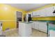 Kitchen featuring stainless steel refrigerator, white cabinets, and an island, as well as a view to a fireplace at 70 Juliana Dr, Ellenwood, GA 30294