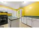 Kitchen features white cabinets, yellow walls, and an island at 70 Juliana Dr, Ellenwood, GA 30294