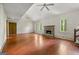 Spacious living room featuring a stone fireplace, ceiling fans, hardwood floors and three large windows at 70 Juliana Dr, Ellenwood, GA 30294