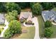Aerial view of a beautiful brick home surrounded by lush green trees, and well-maintained landscaping at 3045 Moss Stone Lane Sw Ln, Marietta, GA 30064